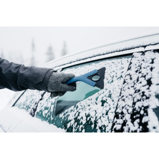 Mid is isskraberen i brug på bilens rude som er sne dækket